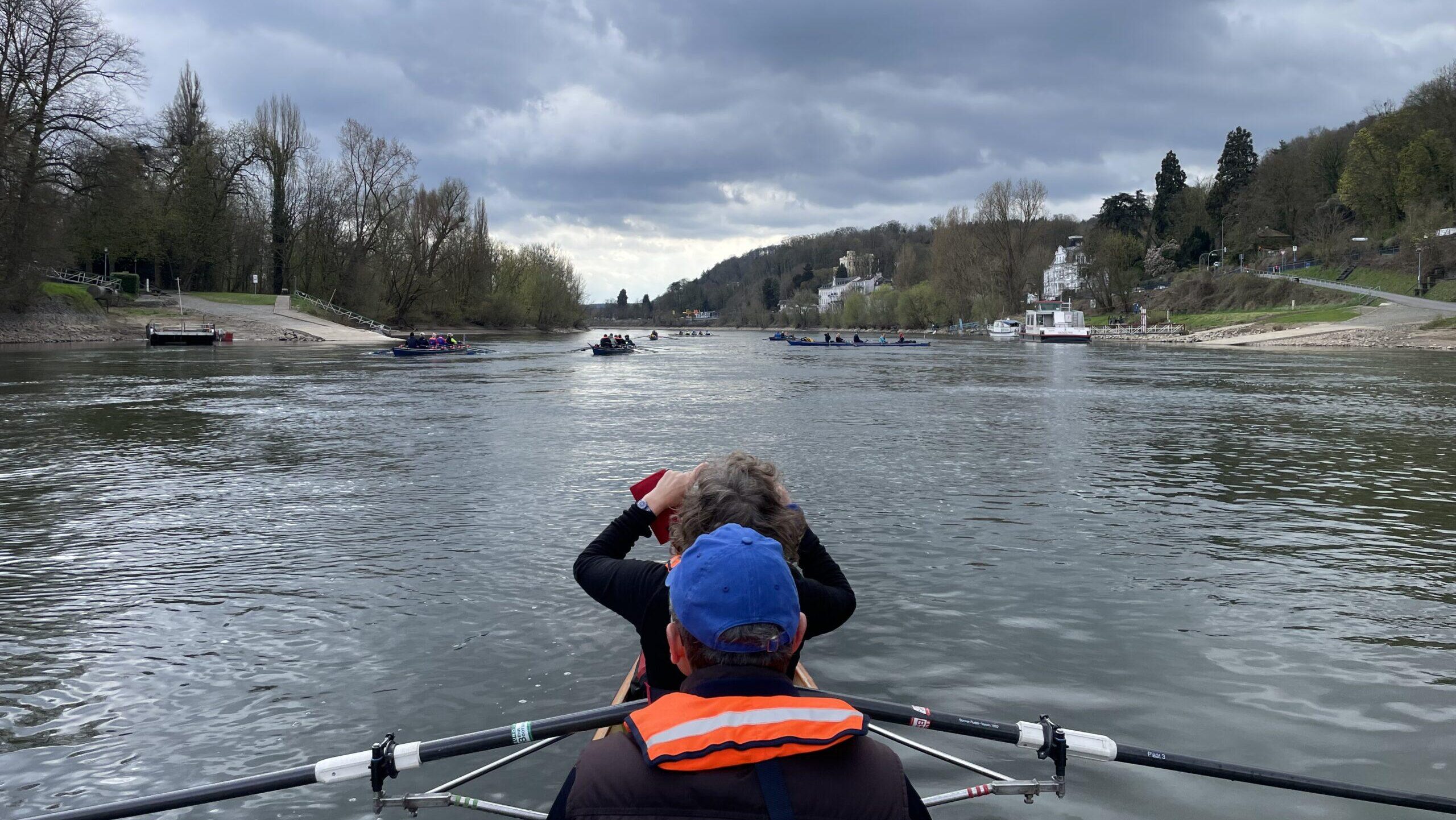 Ruderboot auf dem Rhein unter grauen Wolken.